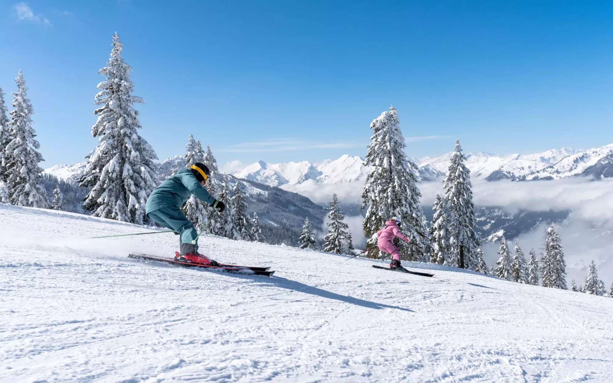 Zwei Skifahrer auf einer sonnigen Piste im Skigebiet Alpendorf