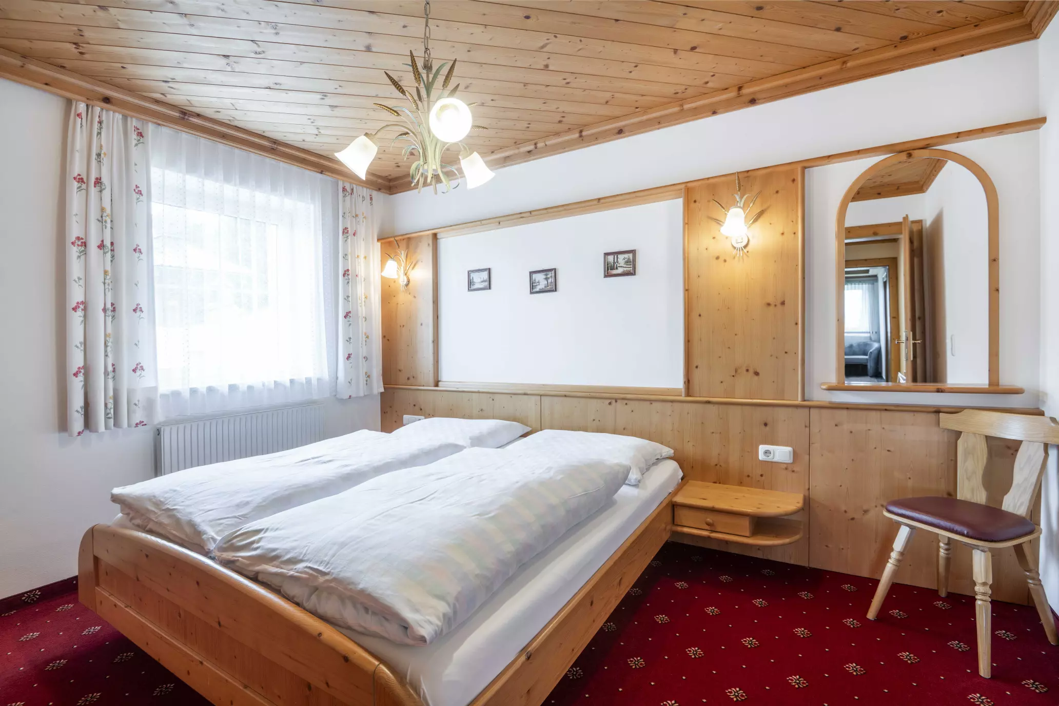 Schlafzimmer mit Doppelbett, Wandleuchten und Spiegel